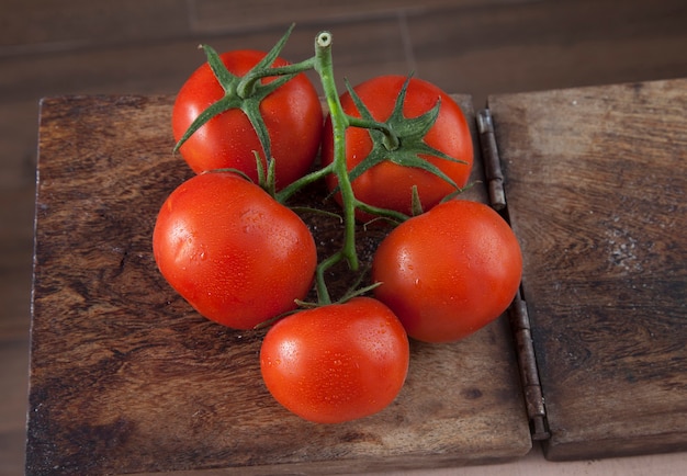 Zdjęcie Świeże pomidory na drewnianym stole w tle