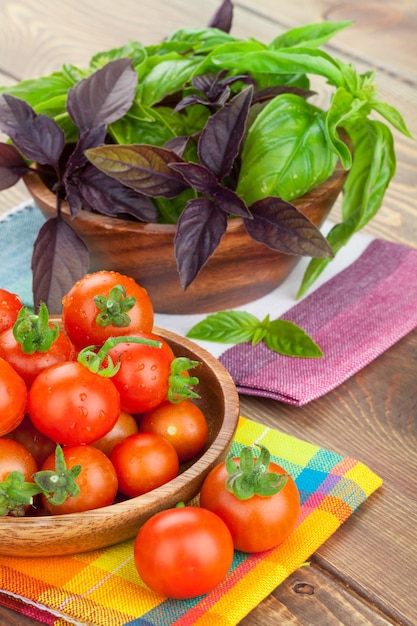 Świeże pomidory rolników i bazylia na drewnianym stole
