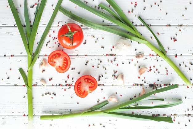 Zdjęcie Świeże pomidory z przyprawami. ekologiczna zdrowa żywność na drewnianym zielonym czosnku. warzywa letnie i jesienne.