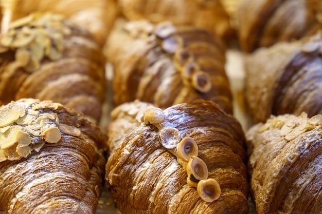 Świeże pyszne bułeczki i rogaliki z orzechami są na ladzie w piekarni Francuskie rogaliki z pistacjami i orzechami laskowymi widok z góry Domowe ciasta