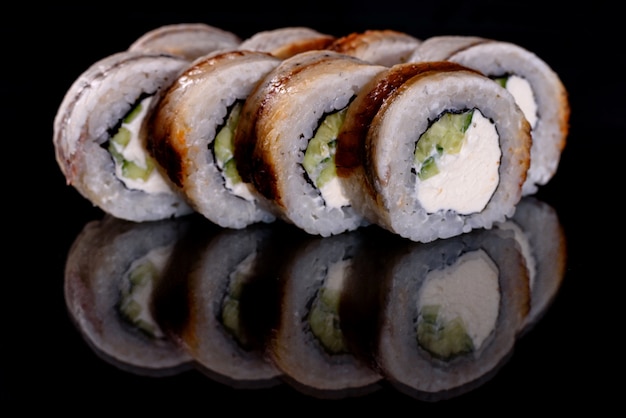 Świeże pyszne piękne sushi rolki na ciemnym tle