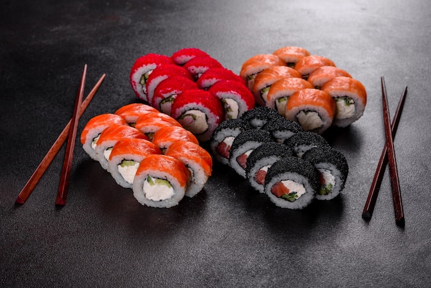 Świeże pyszne piękne sushi rolki na ciemnym tle