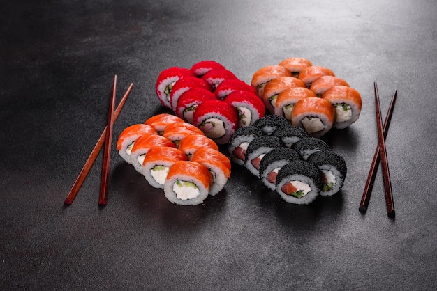 Świeże pyszne piękne sushi rolki na ciemnym tle