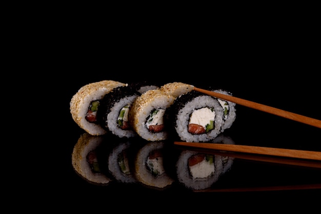 Świeże pyszne sushi rolki na ciemnym tle