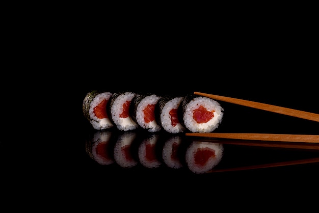 Świeże pyszne sushi rolki na ciemnym tle