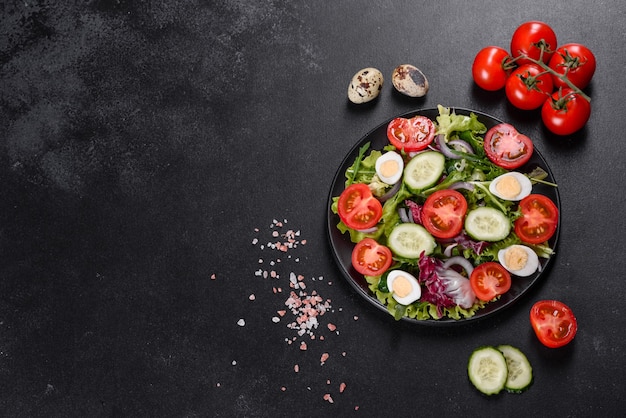 Świeże pyszne wegetariańskie sałatki posiekanych warzyw na talerzu na ciemnym tle betonu