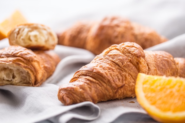 Świeże rogaliki maślane ze słodkimi pomarańczami na serwetce kuchennej.