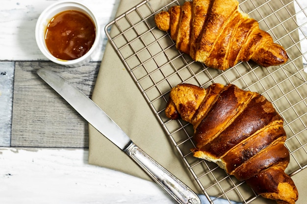 Świeże słodkie croissanty z dżemem pomarańczowym na śniadanie Śniadanie kontynentalne na drewnianym stole Z góry