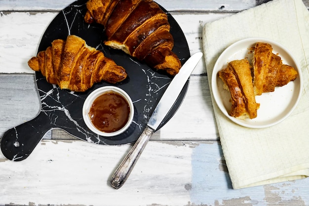 Świeże słodkie croissanty z dżemem pomarańczowym na śniadanie Śniadanie kontynentalne na drewnianym stole Z góry