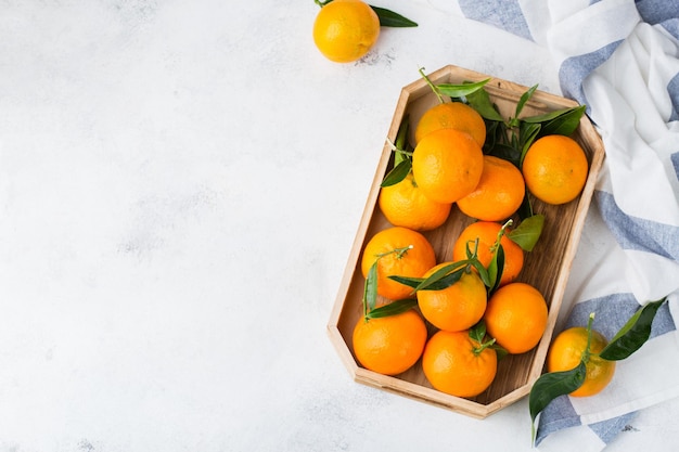 Świeże soczyste organiczne mandarynki pomarańczowe mandarynki z zielonymi liśćmi na stole kuchennym Zdrowa witamina jedzenie koncepcja Skopiuj tło