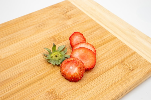 Świeże starwberries w plasterkach na górnym kącie deski do krojenia