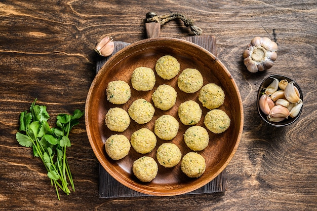 Świeże surowe kule falafel w drewnianej tablicy