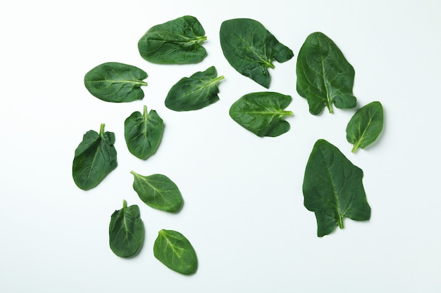 Świeże, surowe liście szpinaku na białej powierzchni