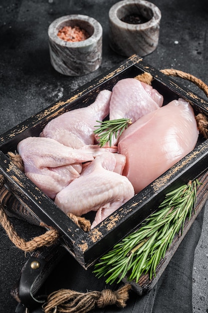 Świeże surowe mięso kurczaka i części kurczaka podudzie filet z piersi udo ze skrzydełek Czarne tło Widok z góry