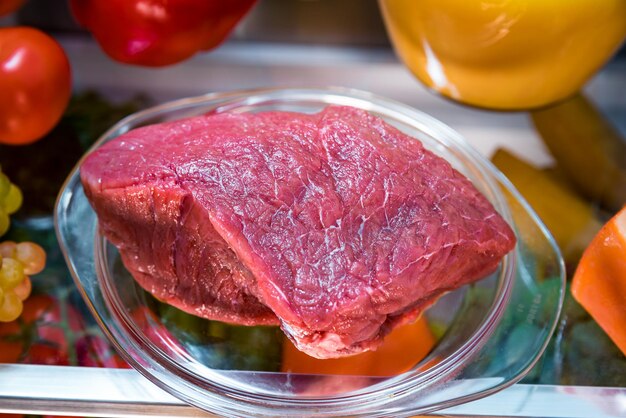 Świeże surowe mięso na otwartej lodówce z półką