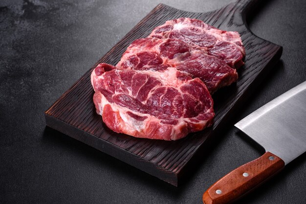 Świeże surowe mięso wołowe do przygotowania pysznego soczystego steku z przyprawami i ziołami.