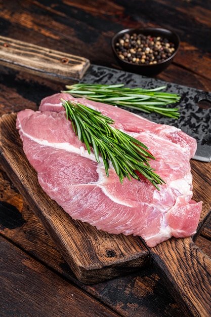 Świeże surowe mięso z łopatki wieprzowej pokrojone ze składnikami i przyprawami na tle kuchni