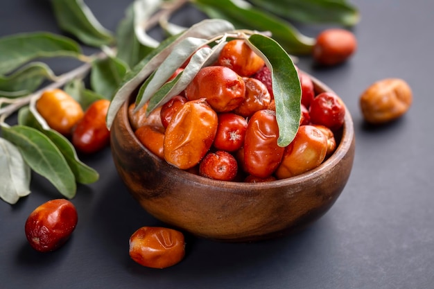 Świeże, surowe owoce borówki w misce z pęczkiem drzewa srebrzystego, oleasterem lub rosyjską oliwką (Elaeagnus)