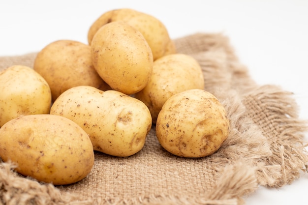 Świeże surowe żółte ziemniaki na białym tle