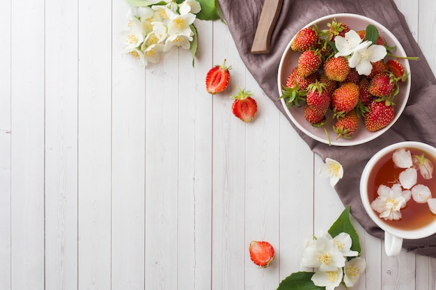 Świeże truskawki i herbata z kwiatami jaśminu