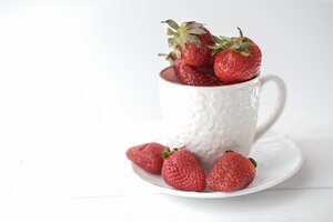 Świeże truskawki w białej herbacianej filiżance