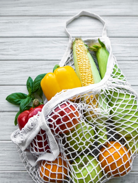 Zdjęcie Świeże warzywa i owoce na ekologicznej torbie sznurkowej na białym drewnianym