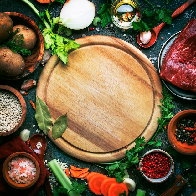 Świeże warzywa organiczne składniki przyprawy i mięso do zupy lub bulionu na vintage kuchennym stole...
