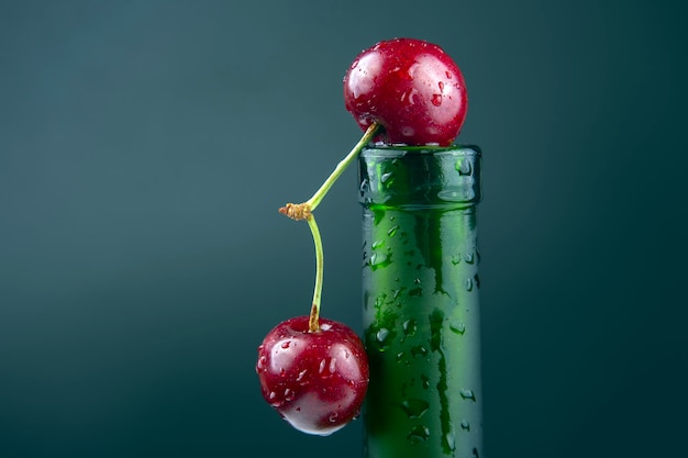 Świeże wiśniowe jagody z kroplami wody na zielonej butelce. zdrowa żywność na śniadanie. owoce roślinności. deser owocowy