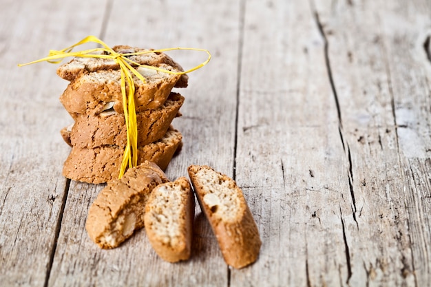 Świeże włoskie ciasteczka cantuccini stos i nasiona migdałów na ructic drewniany stół