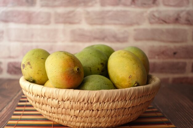 Świeże zielone mango w misce na stole