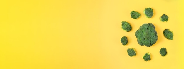 Świeże zielone warzywo brokułów na żółtym Słoneczna głowa kapusty brokułowej na kolorowym tle