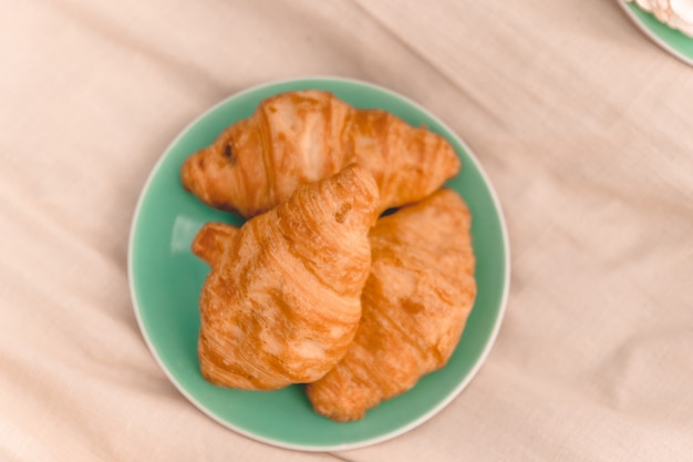 Świezi croissants na zielonym talerzu