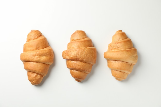 Świeżo piec croissants na białym tle, odgórny widok