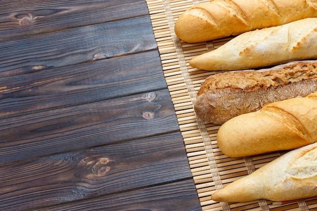 Świeżo piec Francuscy baguettes na białym drewnianym stole. Widok z góry