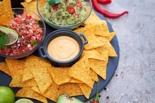 Świeżo Przyrządzony Sos Z Salsy I Guacamole Z Chipsami Nacho Na Kamiennej Desce Do Serwowania