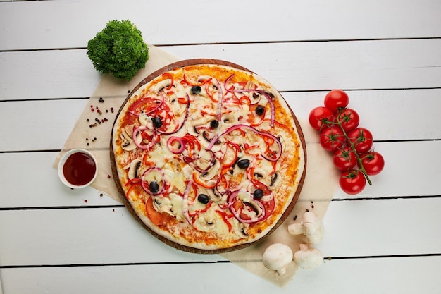 Świeżo Upieczona Pizza Wegetariańska Z Pomidorami, Pieczarkami, Czerwoną Papryką, Oliwkami, Cebulą I Mozzarellą Podawana Na Drewnianym Tle Z Sosami I Ziołami Koncepcja Dostawy żywności Menu Restauracji