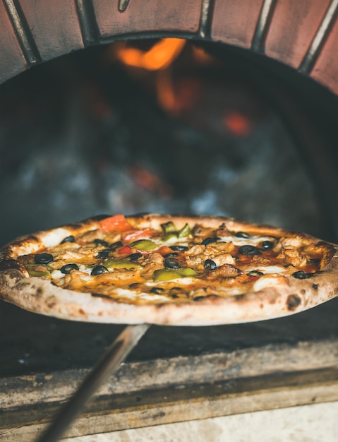 Świeżo upieczona pizza z warzywami w piecu opalanym drewnem