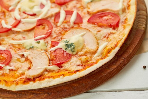 Świeżo upieczona pizza z wędzonym filetem z kurczaka i serem gorgonzola podawana na drewnianym tle z sosem pomidorowym i ziołami Koncepcja dostawy żywności Menu restauracji