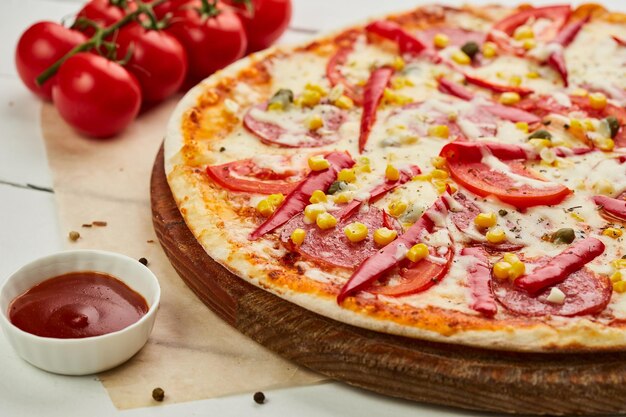 Świeżo upieczona smaczna pizza pepperoni z serem salami mozzarella kukurydza i papryka podawana na drewnianym tle z sosem pomidorowym i ziołami Koncepcja dostawy żywności Menu restauracji