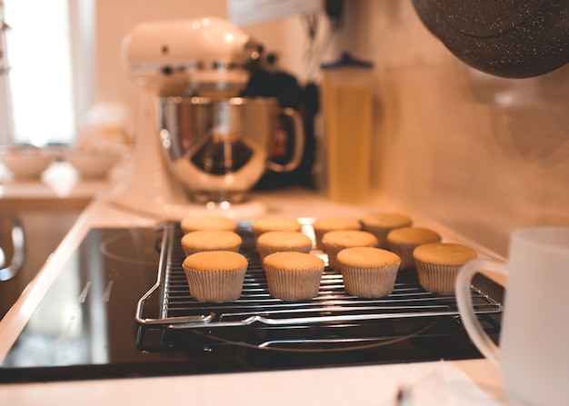 Świeżo upieczone babeczki chłodzone na metalowej tacy na stole kuchennym