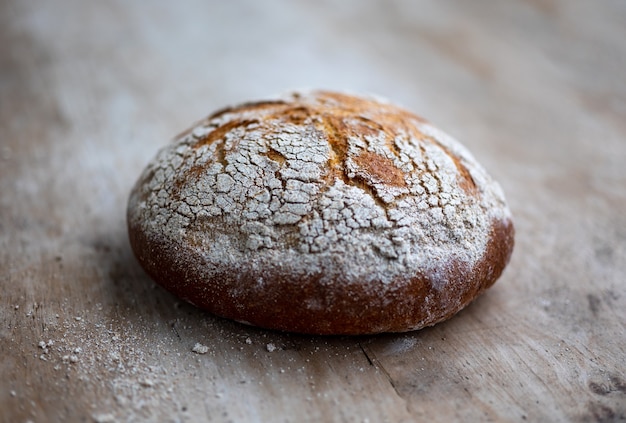 Świeżo upieczony chleb na rustykalnym drewnianym stole kuchennym, selektywne skupienie