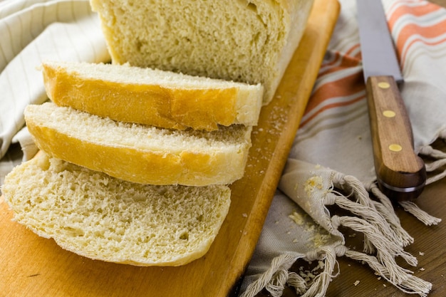 Świeżo upieczony chleb na zakwasie pokrojony na deskę do krojenia.