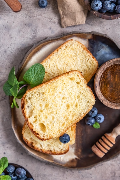 Zdjęcie Świeżo upieczony miękki puszysty chleb lub brioche z jagodami i miodem koncepcja zdrowego śniadania