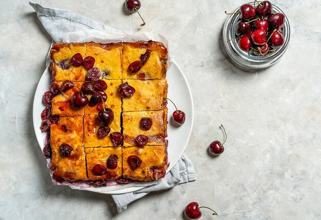 Świeżo upieczony placek z czereśni lub ciasto z czerwonym brownie na talerzu z lawendą i surowymi jagodami na bok