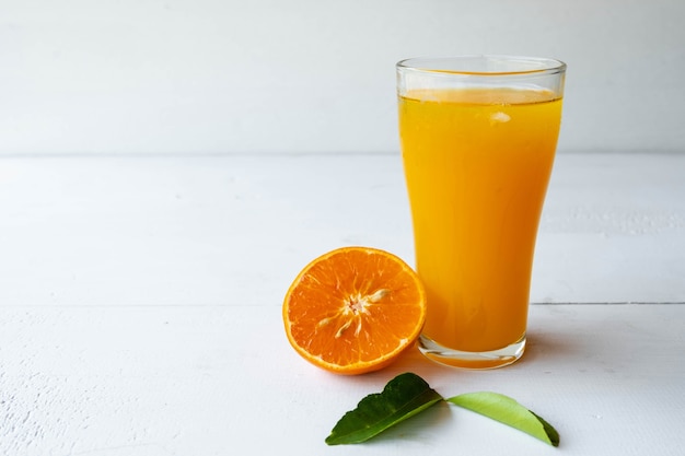 Świeżo wyciśnięty sok z pomarańczy i przekrojone na pół owoce pomarańczy