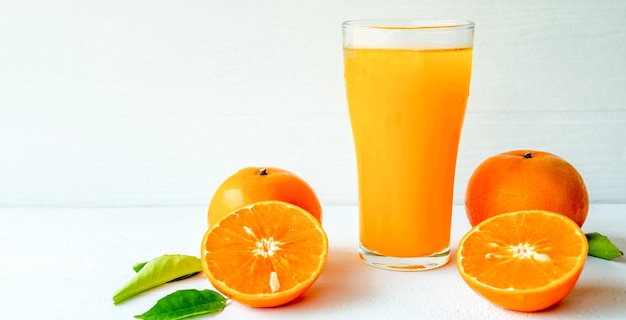 Świeżo wyciśnięty sok z pomarańczy i przekrojone na pół owoce pomarańczy