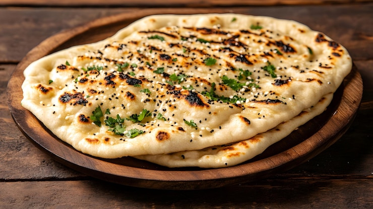 Zdjęcie świeżo zrobiony chleb naan na drewnianej talerzu
