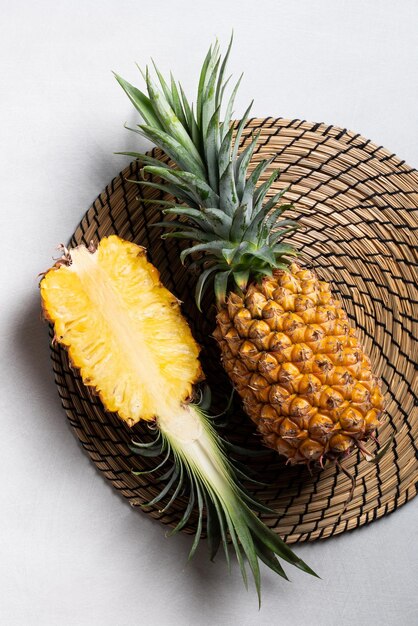 Świeży ananas z tropikalnymi liśćmi na ciemnoniebieskim tle