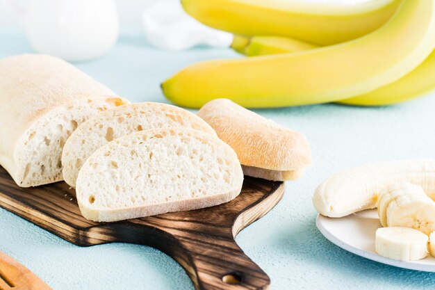 Świeży chleb bananowy pokrojony i banany na talerzu na stole Domowe wypieki Zbliżenie