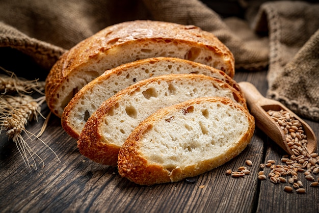 Świeży chleb na drewnianej ziemi. Świeżo upieczony tradycyjny chleb na drewnianym stole. Zdrowe jedzenie